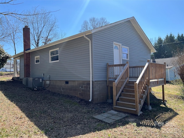 back of property with central AC, stairway, a wooden deck, crawl space, and a chimney