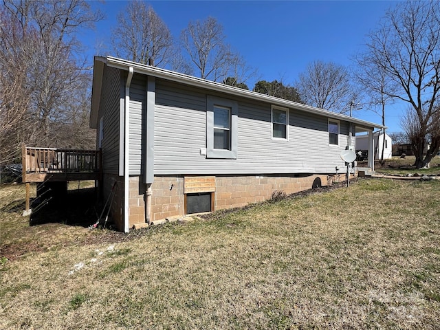 view of side of home featuring a lawn and a wooden deck