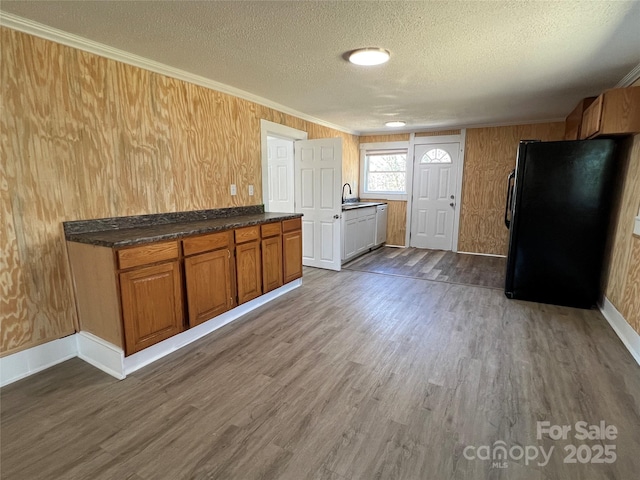 kitchen featuring a textured ceiling, dark wood-style floors, freestanding refrigerator, and a sink