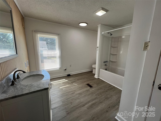 bathroom with vanity, wood finished floors, visible vents, a textured ceiling, and toilet