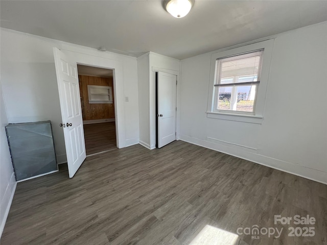 unfurnished bedroom with dark wood finished floors and baseboards