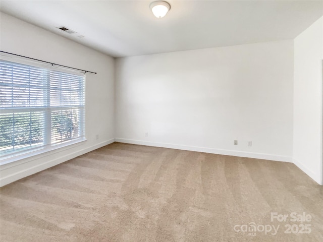 unfurnished room featuring baseboards and carpet