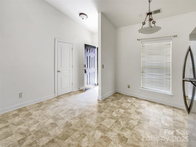 unfurnished room with lofted ceiling and baseboards