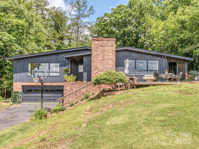 109 Joe Teague Rd, Hickory, NC 28601 - mid-century modern home with asphalt driveway, a garage, a chimney, brick siding, and a front lawn