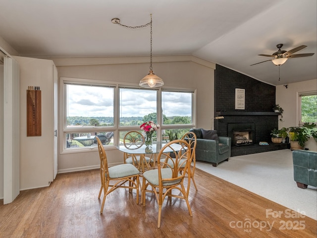 109 Joe Teague Rd, Hickory, NC 28601 - dining area with a ceiling fan, vaulted ceiling, light wood-style flooring, a fireplace, and baseboards