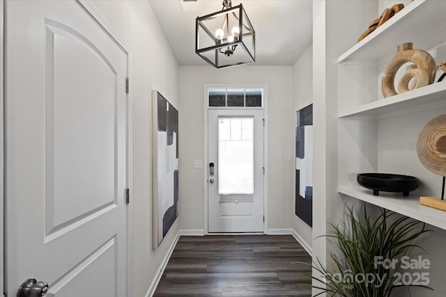 entryway with a notable chandelier, baseboards, and dark wood-type flooring