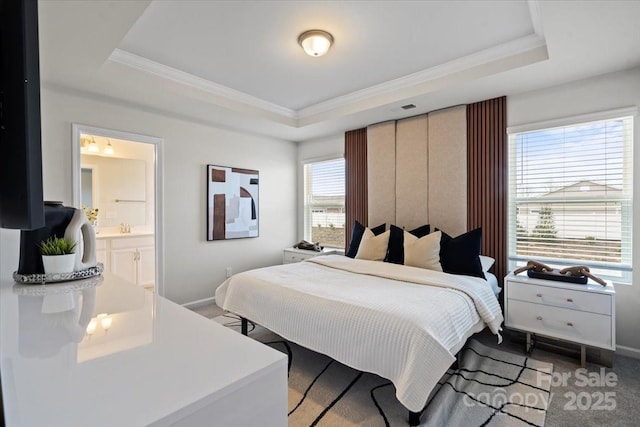 carpeted bedroom featuring a tray ceiling, baseboards, and ornamental molding