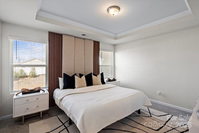 bedroom with a tray ceiling, light carpet, baseboards, and crown molding