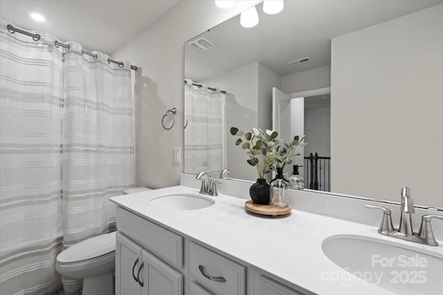 bathroom with visible vents, toilet, and a sink