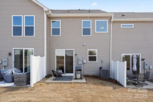 rear view of property featuring cooling unit, a patio area, fence, and a lawn