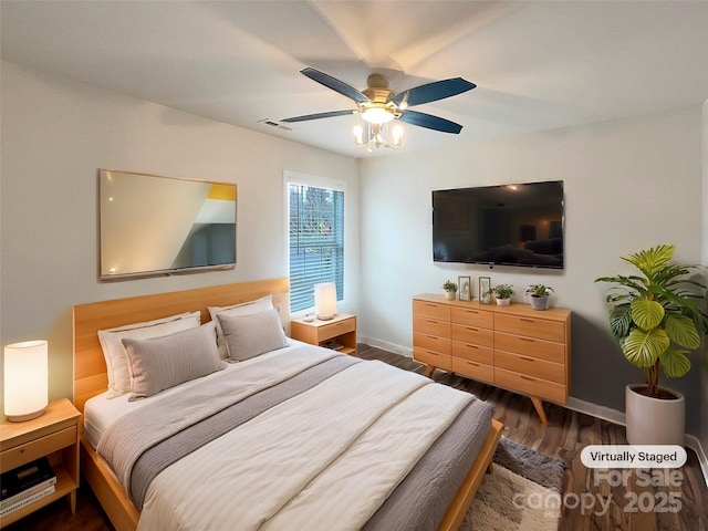 bedroom featuring visible vents, a ceiling fan, dark wood-type flooring, and baseboards