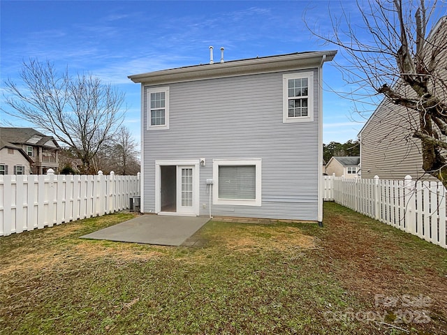 rear view of property featuring a yard, a patio area, and a fenced backyard