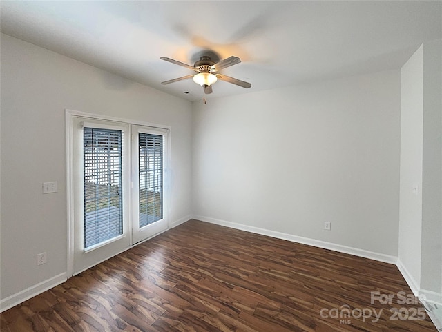 unfurnished room featuring baseboards, dark wood finished floors, and a ceiling fan