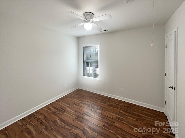 unfurnished room with attic access, baseboards, visible vents, and dark wood-type flooring