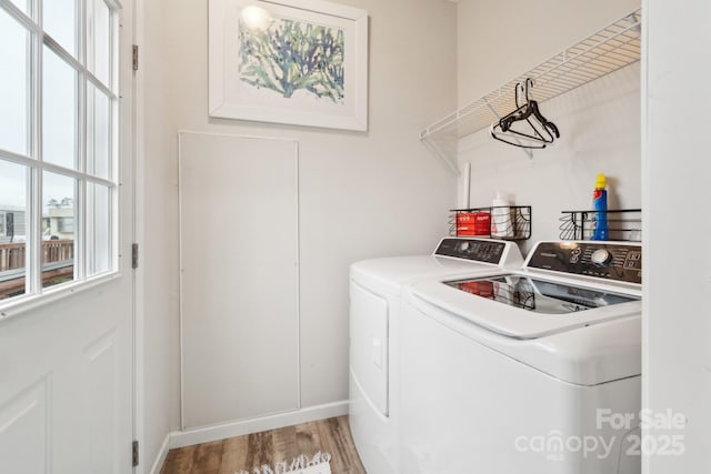 washroom with a wealth of natural light, wood finished floors, laundry area, and washer and clothes dryer