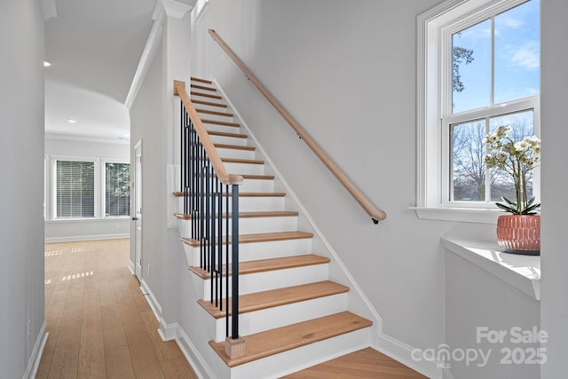 stairway with crown molding, recessed lighting, wood finished floors, and baseboards