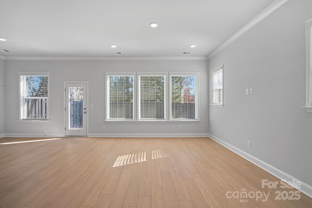 unfurnished living room featuring visible vents, baseboards, light wood-style flooring, and crown molding