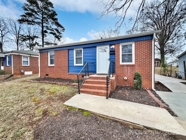 bungalow-style house featuring brick siding and crawl space