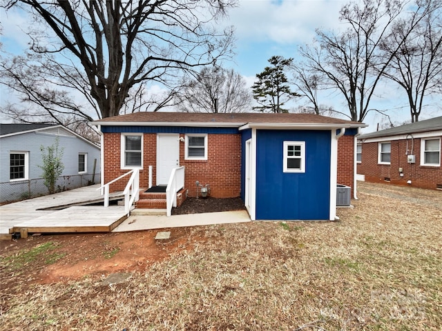 exterior space featuring brick siding and central AC