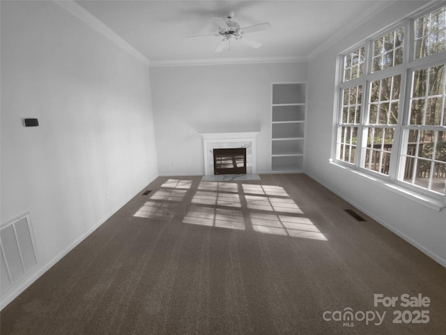 unfurnished living room featuring ornamental molding, visible vents, a high end fireplace, and carpet floors