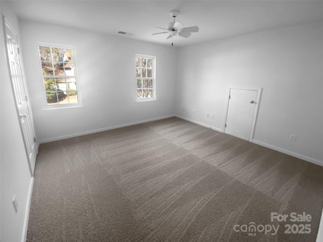 carpeted spare room featuring visible vents, plenty of natural light, baseboards, and a ceiling fan