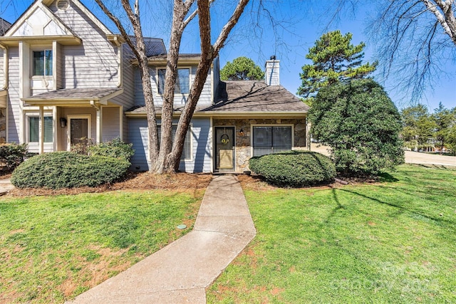 view of front of property featuring stone siding, a chimney, and a front lawn