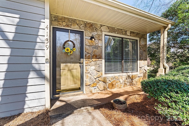 property entrance featuring stone siding