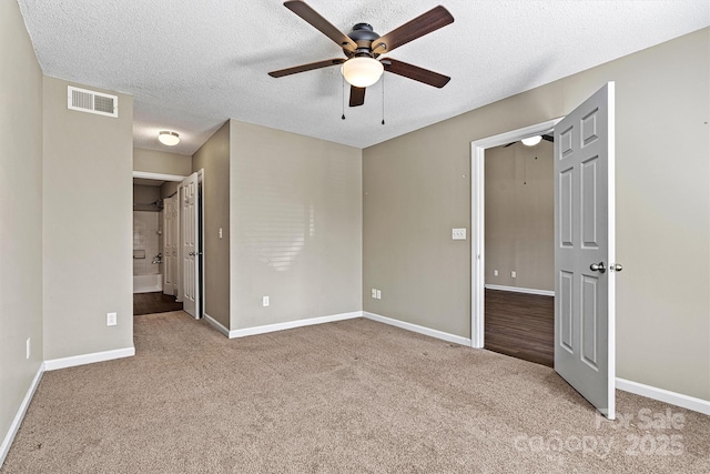 unfurnished bedroom featuring carpet flooring, baseboards, visible vents, and a textured ceiling