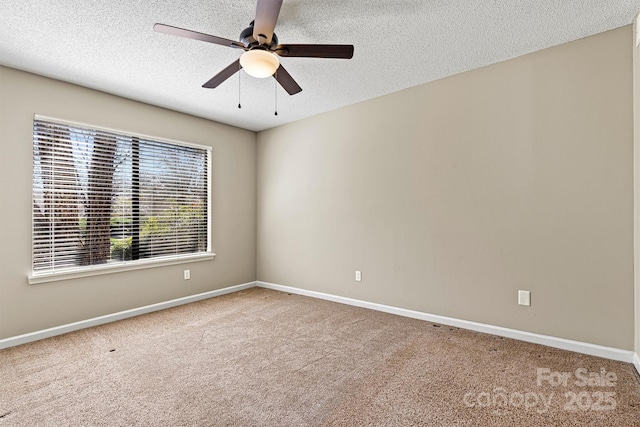 carpeted spare room with baseboards and a textured ceiling