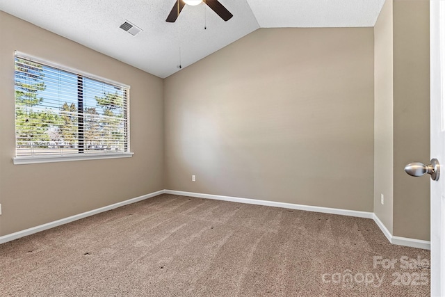 empty room with carpet, visible vents, baseboards, ceiling fan, and vaulted ceiling