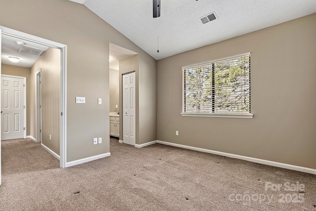 unfurnished bedroom with visible vents, baseboards, carpet flooring, and vaulted ceiling