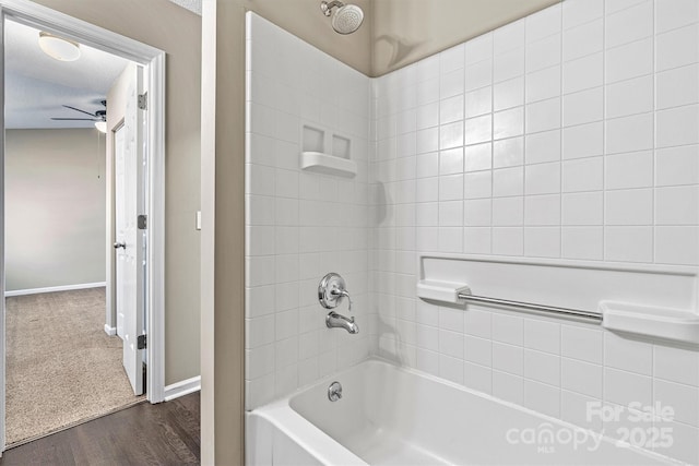 bathroom with baseboards, shower / bathtub combination, ceiling fan, and wood finished floors