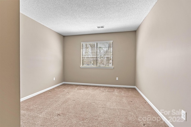 carpeted spare room with baseboards and a textured ceiling