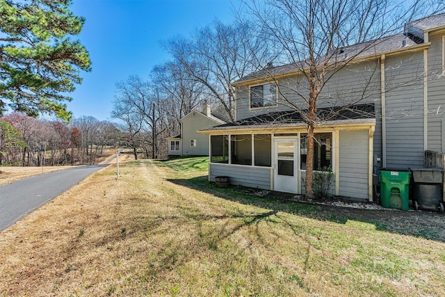 rear view of property with a yard and a sunroom