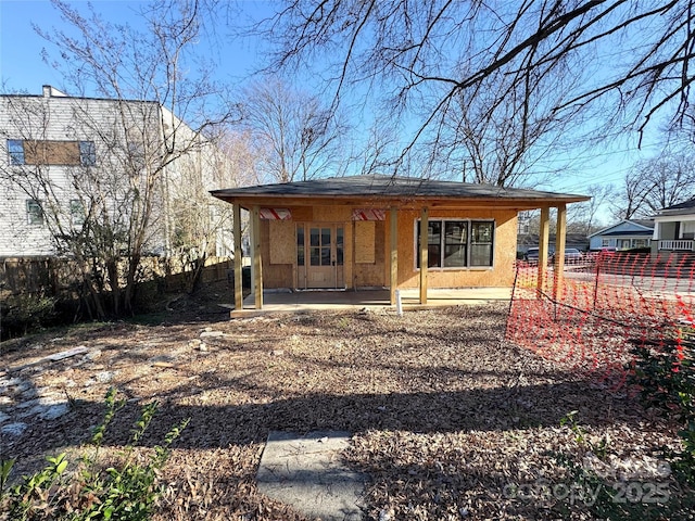 exterior space with stucco siding, a porch, and fence