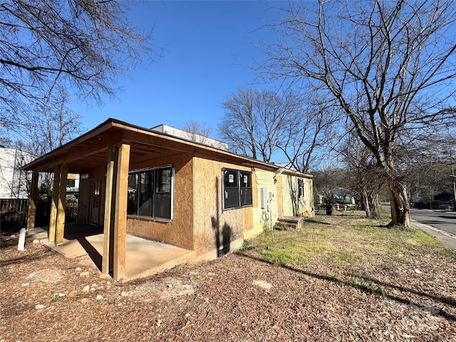 view of side of property featuring stucco siding and a patio