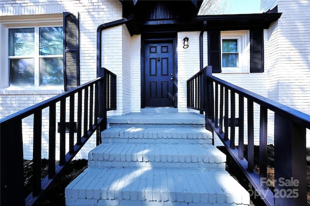 view of exterior entry featuring brick siding