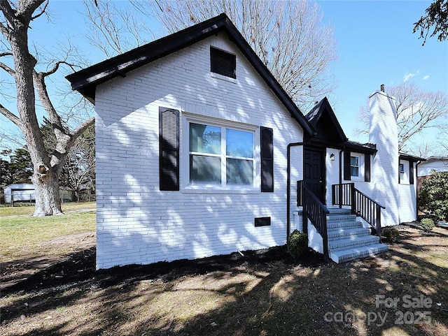 view of front of property with brick siding and a chimney