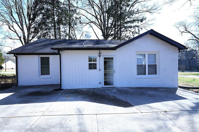 view of front of house with a patio and brick siding