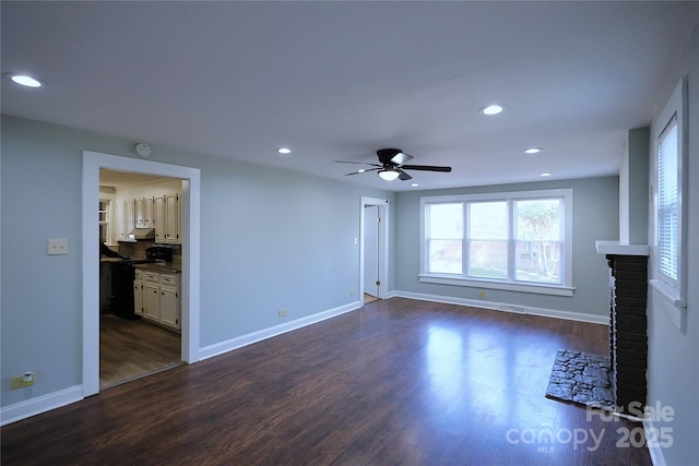 unfurnished living room featuring recessed lighting, baseboards, and dark wood finished floors