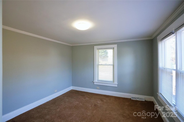 unfurnished room featuring dark colored carpet, visible vents, baseboards, and ornamental molding