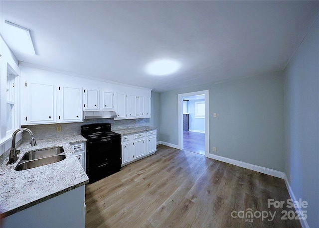 kitchen with light wood-style flooring, a sink, decorative backsplash, white cabinets, and black electric range oven