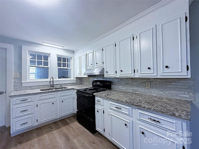 kitchen with under cabinet range hood, a sink, white cabinets, and black electric range