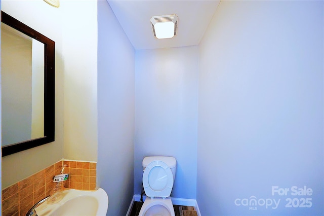 bathroom featuring toilet, visible vents, and a sink