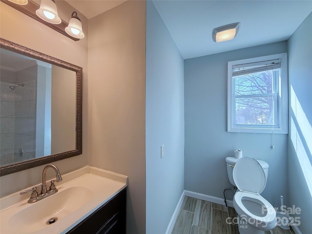 bathroom featuring vanity, toilet, and baseboards