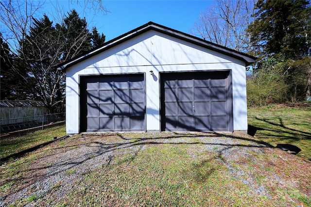 detached garage featuring fence