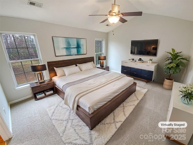 carpeted bedroom with visible vents, a ceiling fan, baseboards, and vaulted ceiling