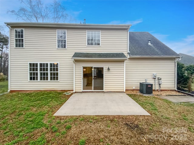 back of house with a lawn, central AC unit, a shingled roof, and a patio area