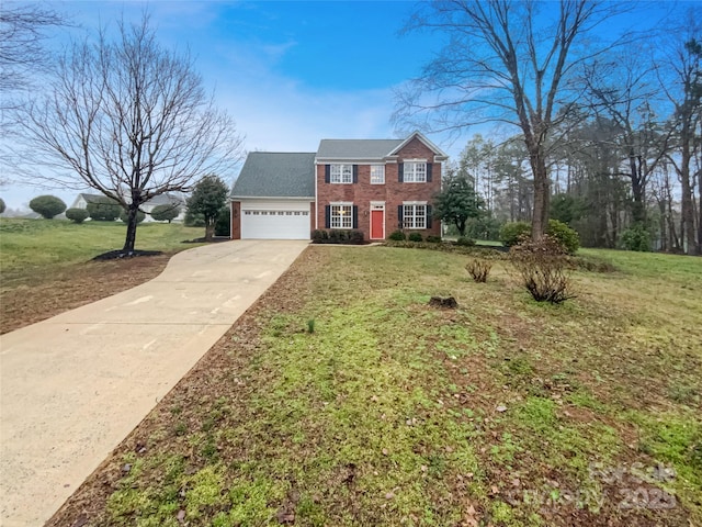 colonial inspired home featuring brick siding, a garage, concrete driveway, and a front yard