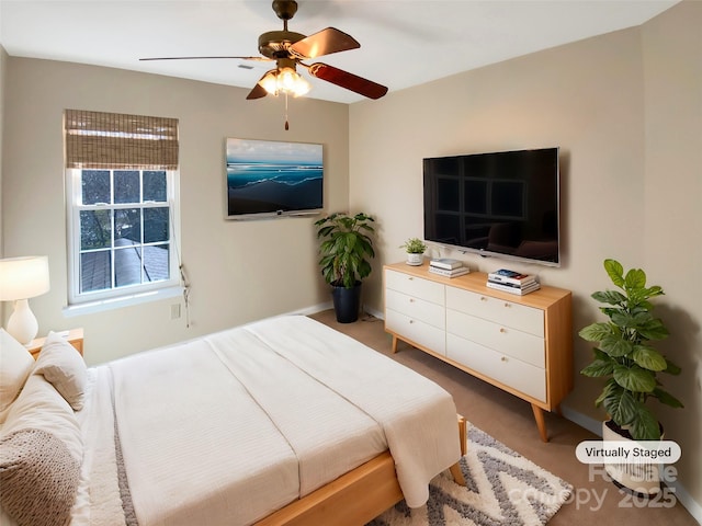 carpeted bedroom featuring baseboards and a ceiling fan